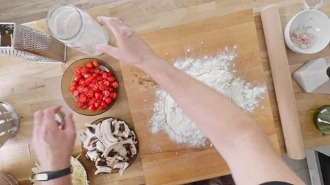 Hands kneading dough on a board, possibly for pizza. Flour is added as the .. Stock Footage 283089598