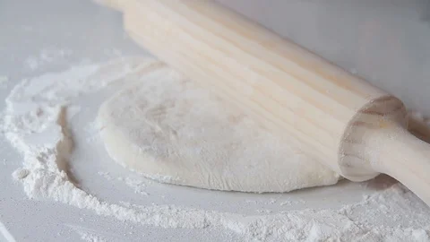 Hands kneading a dough for bread with a rolling pin Stock Footage 98682367