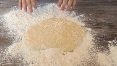Hands kneading dough in flour on the table Stock Footage 131124273