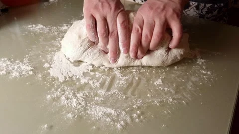 Hands kneading dough on a floured kitchen table in slow motion Stock Footage 330761475