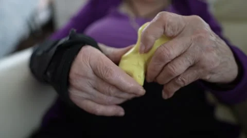 Hands Kneading Playdough for Therapeutic Exercise in a Cozy Indoor Setting Stock Footage 305523102