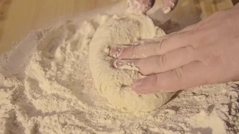 Hands kneading soft dough on floured wooden surface Видео 323143520