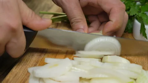 Hands with knife cut onion on Kitchen Board. Cooking food at home Stock Footage 91087679