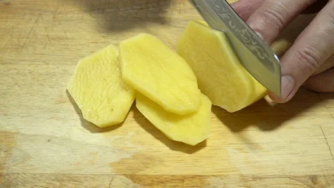 Hands with a knife cut raw potatoes in slow motion Stock Footage 128801733