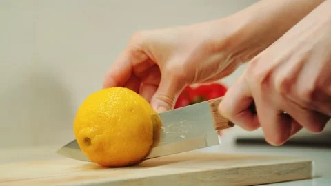 Hands with knife cutting lemon on the kitchen board Stock-Footage 143352361