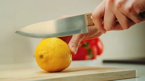 Hands with knife cutting lemon on the kitchen board Stock Footage 143390448