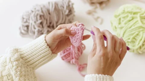 Hands knit with crochet hook and woolen fluffy pink threads Stock Footage 211734798