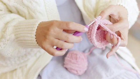 Hands knit with crochet hook and woolen fluffy pink threads. Stock Footage 213303391
