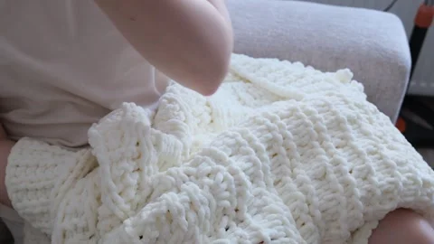 Hands knitting chunky white plush cardigan sweater close up Видео 337151817