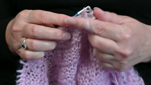 Hands knitting pink wool yarn, metal needles working loops. Stock Footage 334752151