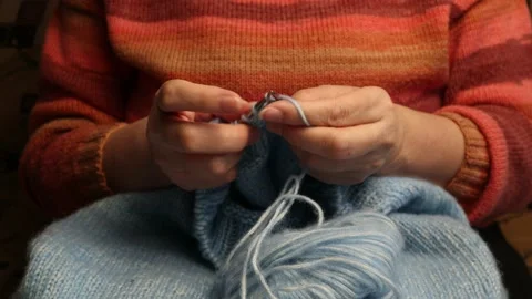 Hands knitting a sweater of blue wool yarn with knitting needles Stock Footage 170717344