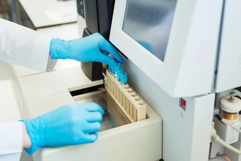 Hands of laboratory assistant loading sample tubes for coagulation test analysis Stock Photos