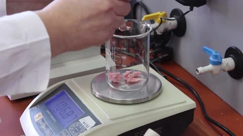 The hands of a laboratory assistant put pink material in a laboratory flask Stock Footage 128374532