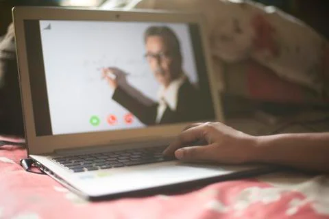 Hands on laptop keypad while attending online classes in home isolation due t Stock Photos