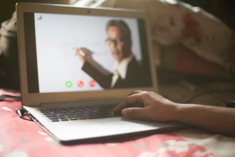 Hands on laptop keypad while attending online classes in home isolation due t Stock Photos