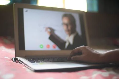Hands on laptop keypad while attending online classes in home isolation due t Stock Photos