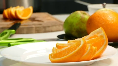 Hands lay an orange on a plate Stock Footage 78286667