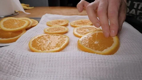 Hands lay orange slices on a kitchen towel and dry them. Close up Stock Footage 116545420