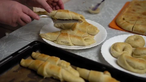 Hands lay out sweet buns on a plate. Stock Footage 120901877