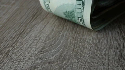 Hands leaf through many dollars in stack on wooden table. Stock Footage 125641175