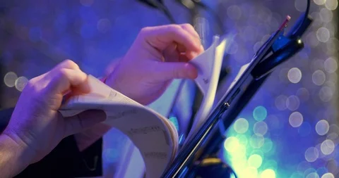 Hands leafing through notes - the orchestra is preparing for the performance Stock Footage 123476922
