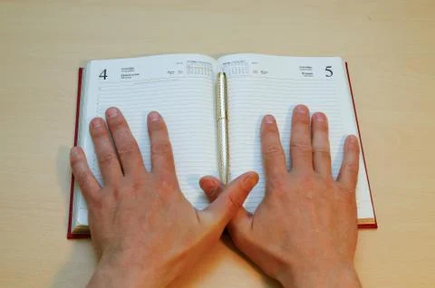 The hands lie on a notebook Stock Photos