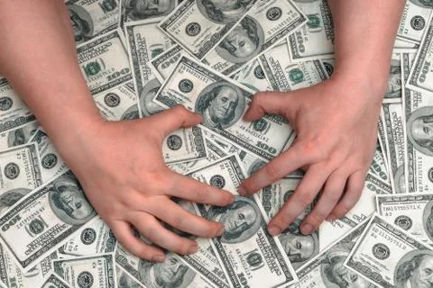Hands lie on top of a huge pile of hundred-dollar bills Stock Photos