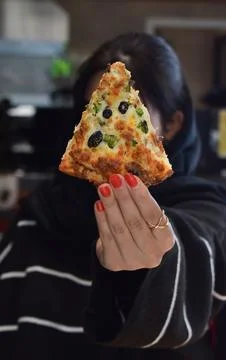 Hands lifting two slices of vegetable cheese pizza Stock Photos