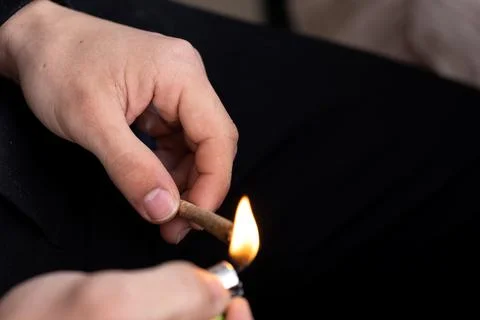 Hands lighting handmade cigarette with a lighter Stock Photos