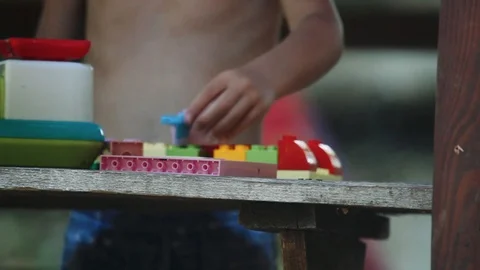 Hands of a little boy play with a constructor in nature Stock Footage 125757073