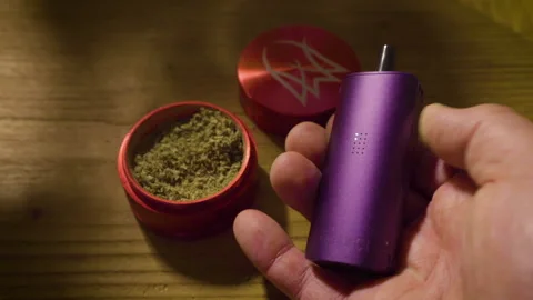 Hands loading and smoking cannabis with a Divinci Miqro vaporizer. Vídeo Stock 146866873