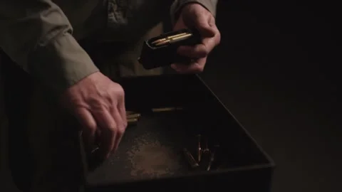Hands Loading Brass Cartridges into a Rifle Magazine, Dark Ammunition Box Stock Footage 341322007