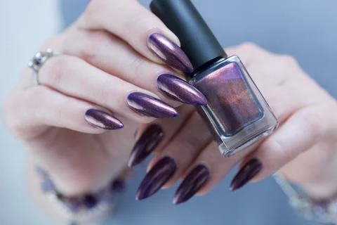 Hands with long nails and black purple manicure Foto stock