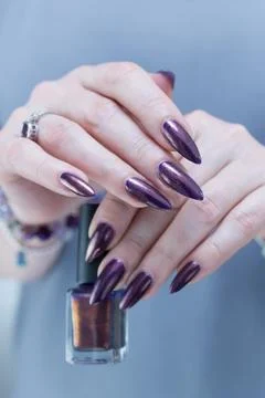 Hands with long nails and black purple manicure Stockfoto's