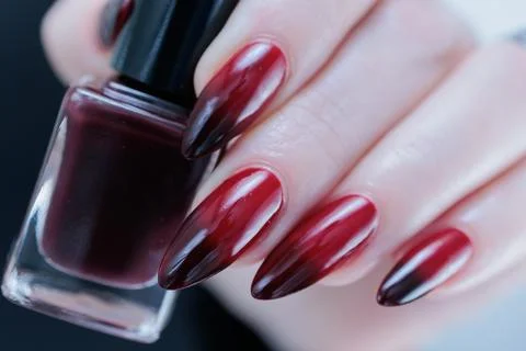 Hands with long nails and black and red nail polish Stockfoto's