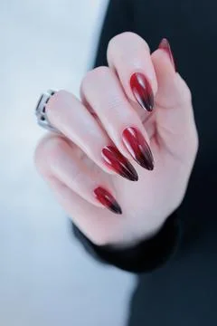 Hands with long nails and black and red nail polish Stockfoto's