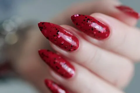 Hands with long nails and a bright red and black manicure Stock Photos