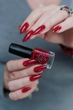 Hands with long nails and a bright red and black manicure Foto stock