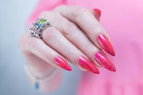 Hands with long nails and bright neon pink and red nail polish Stock Photos