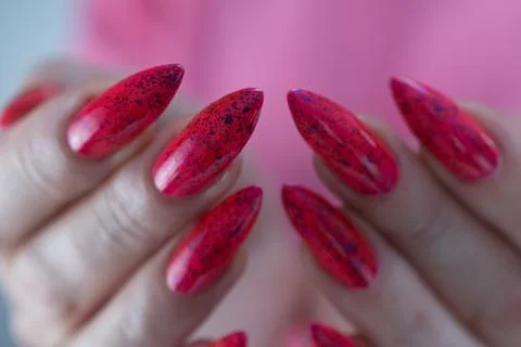 Hands with long nails and bright neon pink and red nail polish Stock Photos