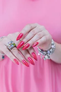 Hands with long nails and bright neon pink and red nail polish Stock Photos