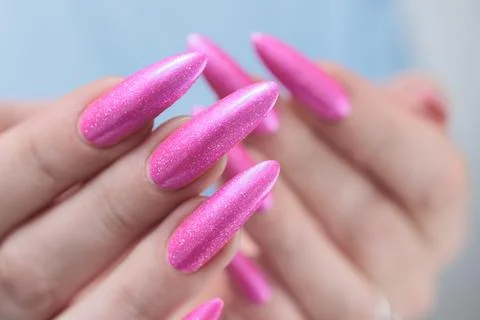 Hands with long nails and bright neon pink red nail polish 스톡 사진