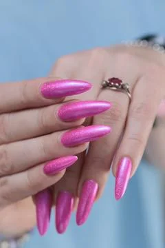 Hands with long nails and bright neon pink red nail polish Photos