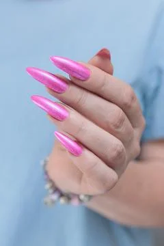 Hands with long nails and bright neon pink red nail polish Foto stock