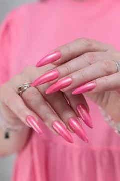 Hands with long nails and bright neon pink red nail polish Stock Photos