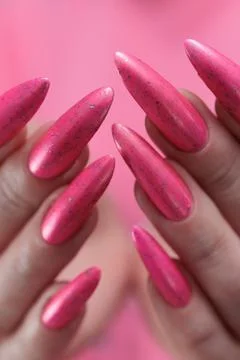 Hands with long nails and bright neon pink red nail polish Foto stock
