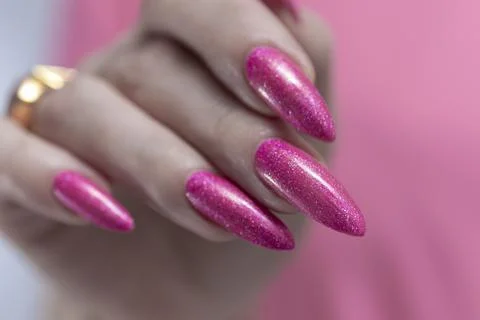 Hands with long nails and bright neon pink nail polish Stock Photos