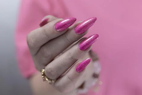 Hands with long nails and bright neon pink nail polish 库存照片