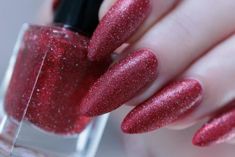 Hands with long nails and dark red nail polish Foto stock