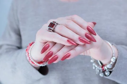 Hands with long nails and dark red nail polish 스톡 사진